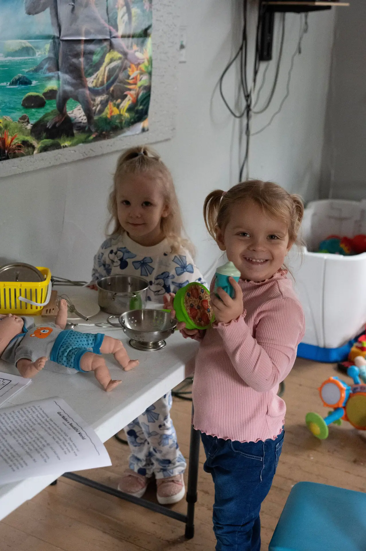 Two young children playing with toys in the church nursery
