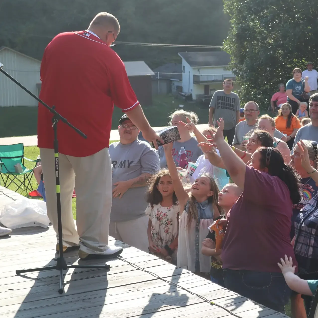 Families gathered around an outdoor stage during a Maple Street community event