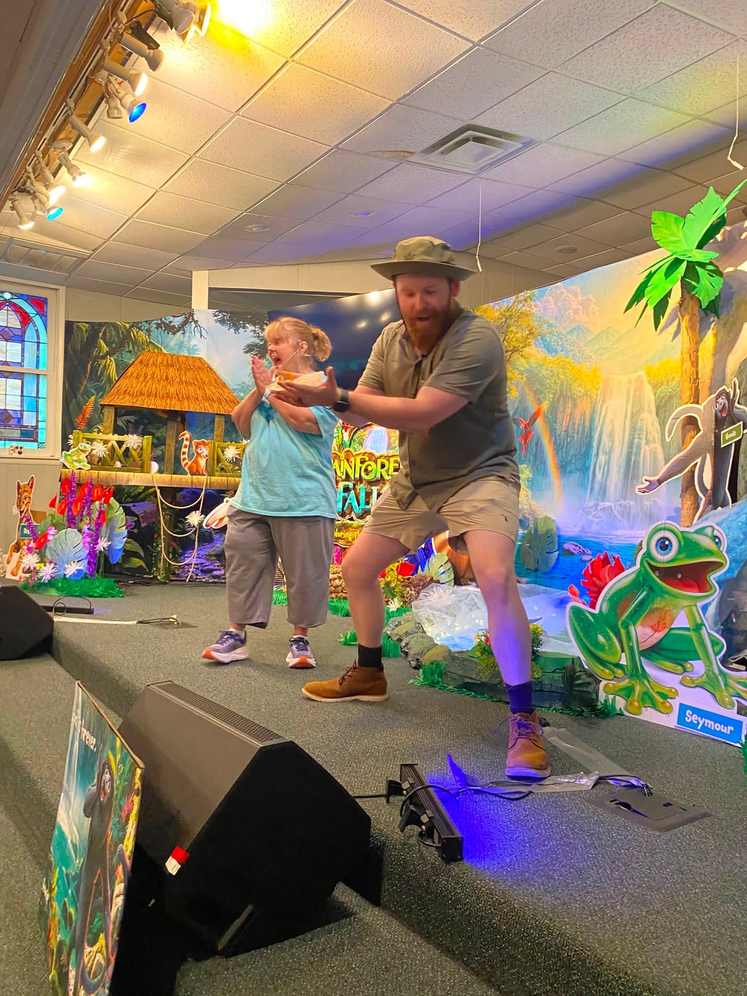 VBS leaders bringing a rainforest-themed lesson to life on stage
