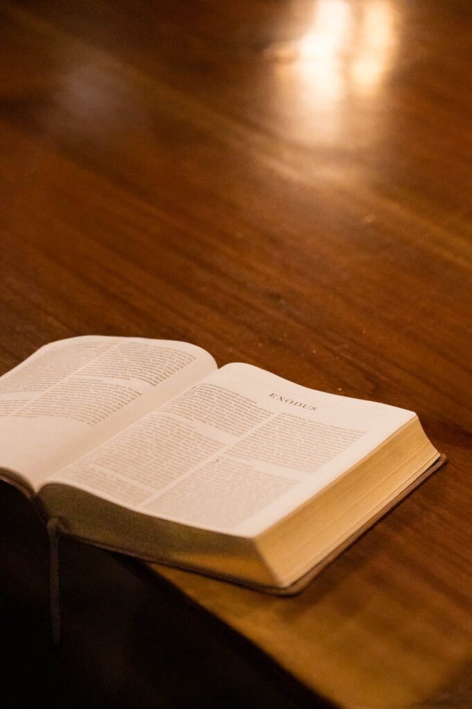 Open Bible on a wooden table, turned to Exodus