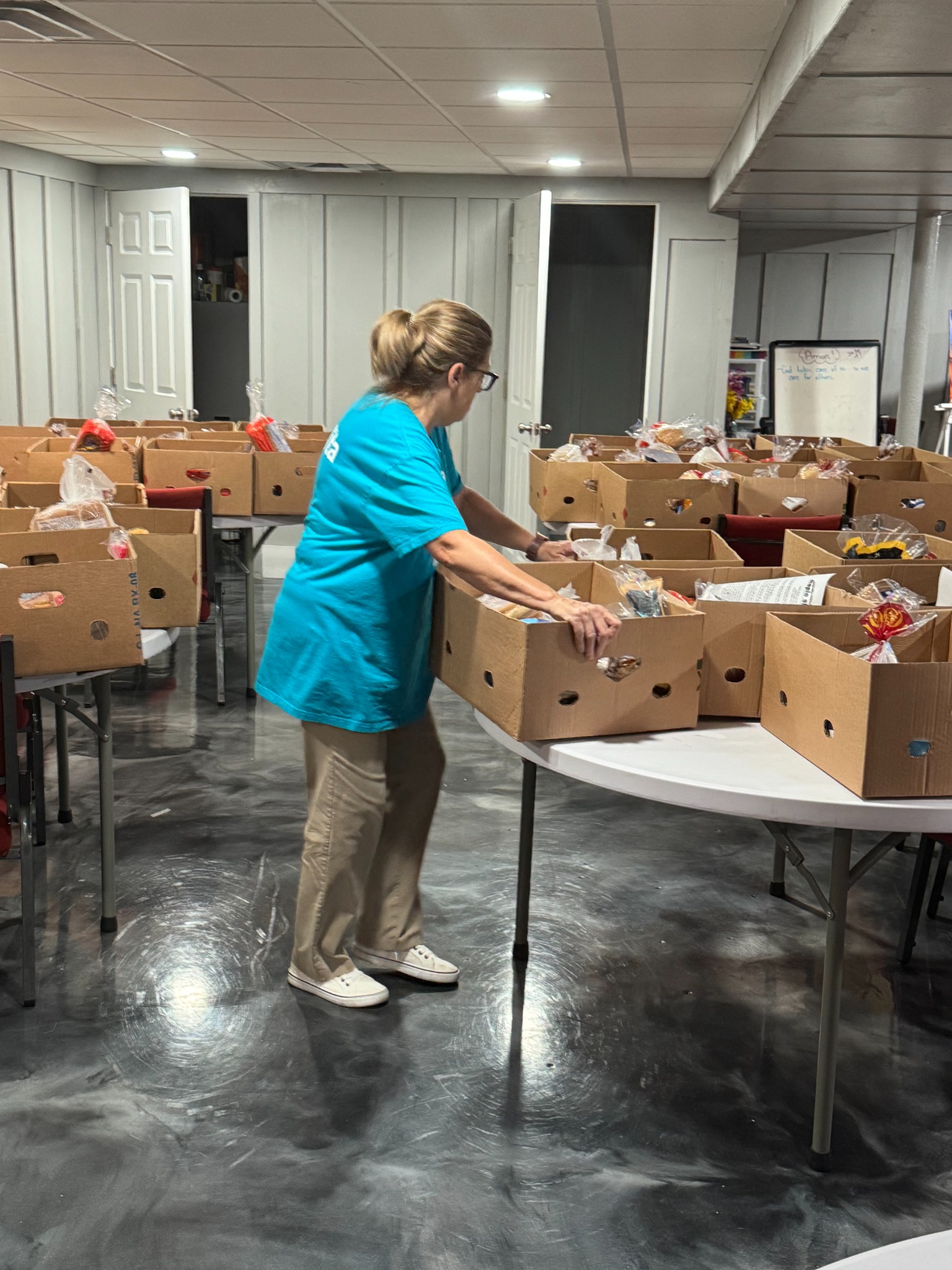A Maple Street volunteer prepares tables of food boxes for the pantry