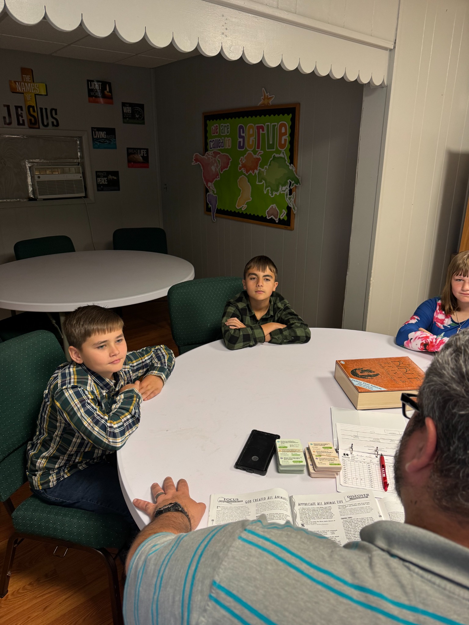 Middle school students gathered around the table for Faith Followers Bible study