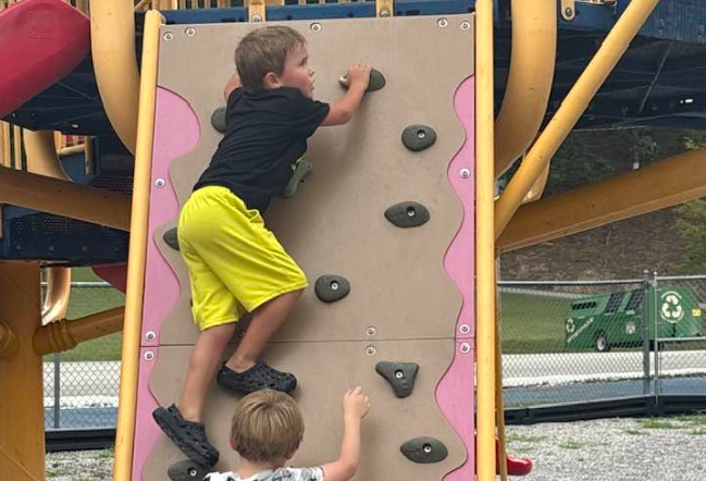 Children climbing a playground wall